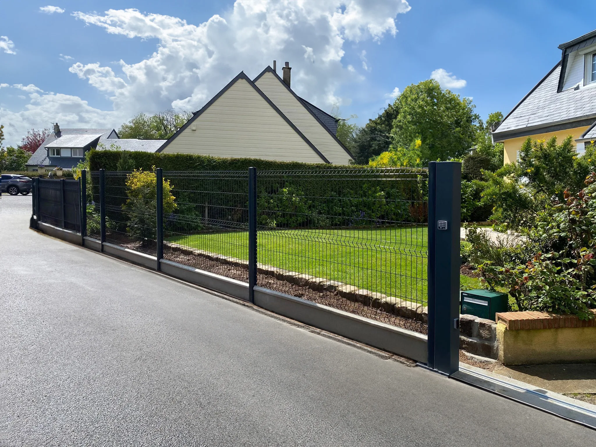 Panneau Rigide Pro+ anthracite installé avec ses poteaux dans un jardin résidentiel.