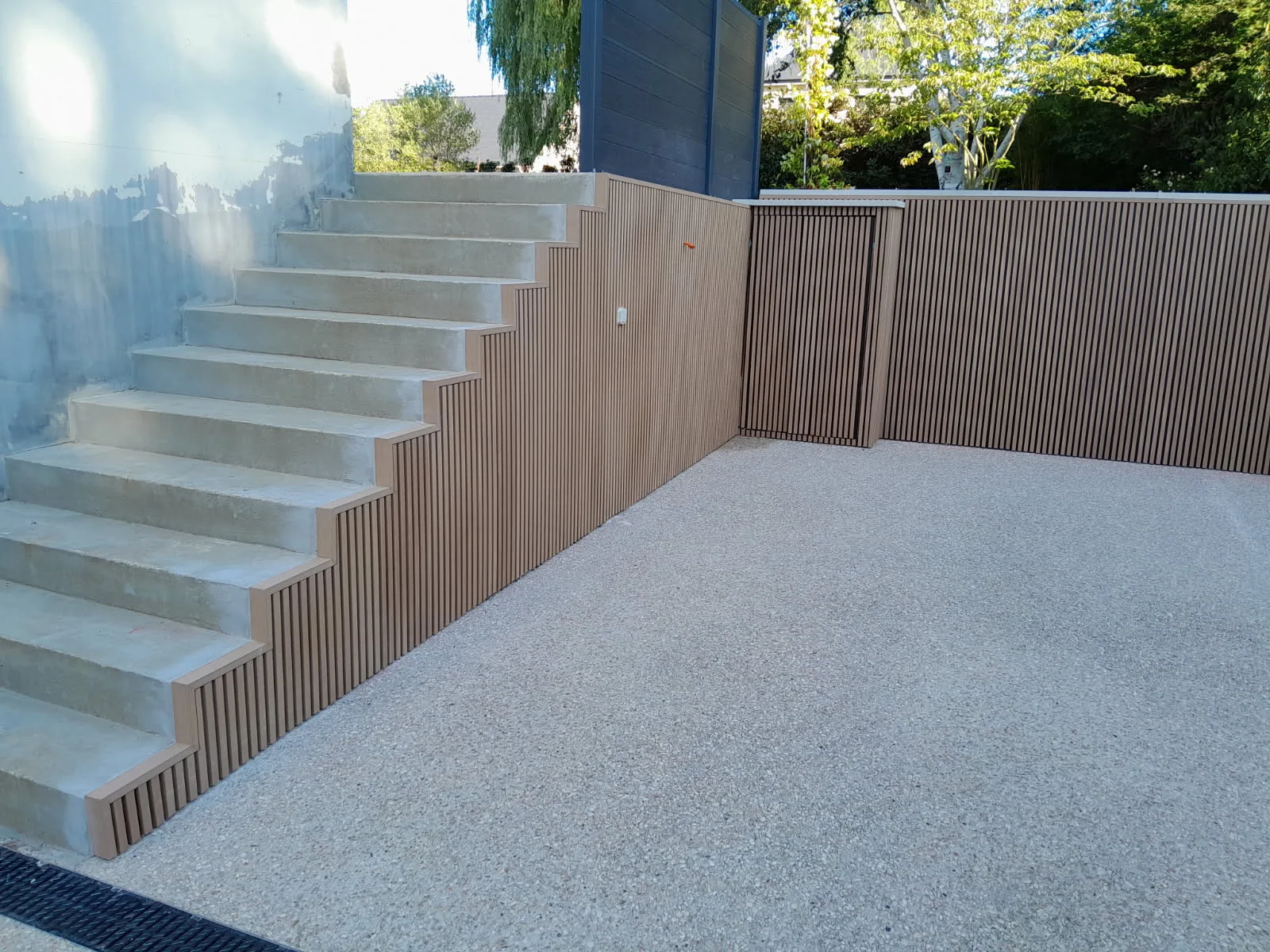 Zona exterior con escaleras, laminillas compuestas y diseño limpio.