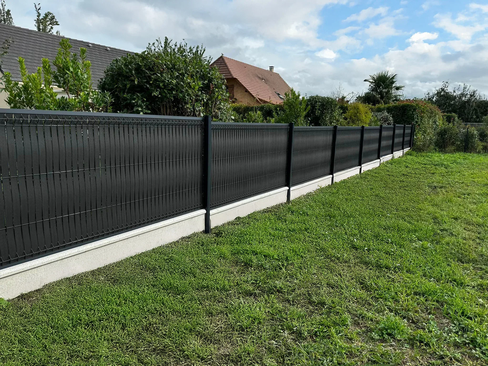 Pannello di recinzione nero professionale su un prato in un cortile residenziale