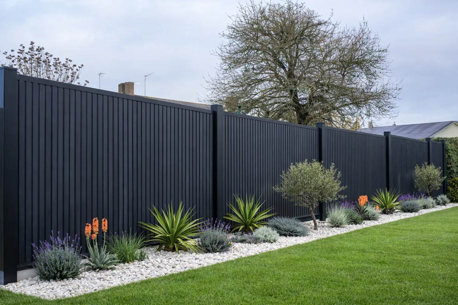 Clôture en aluminium noire avec plantes et gazon dans un jardin moderne.